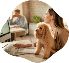 Woman with a dog at a desk in an office setting